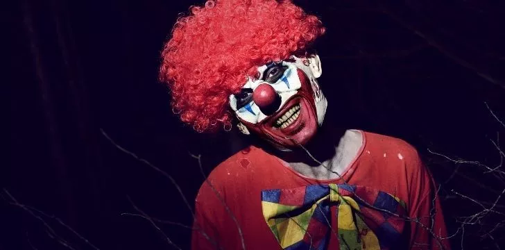 Страшный клоун в кроваво-красном парике