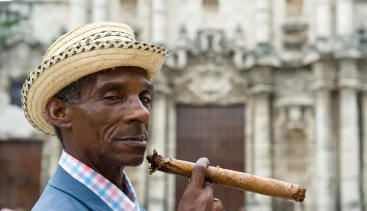 Мужчина курит кубинскую сигару