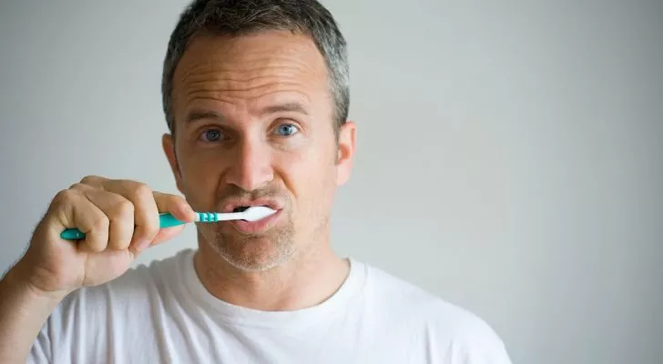 Мужчина чистит зубы