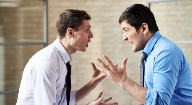 Двое мужчин в рубашках и галстуках спорят