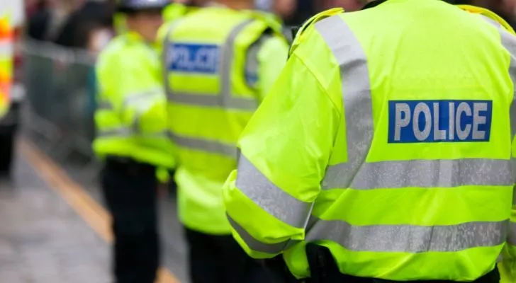 Полицейские Великобритании выстраиваются напротив толпы на улице
