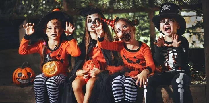 Дети сидят в костюмах на Хэллоуин