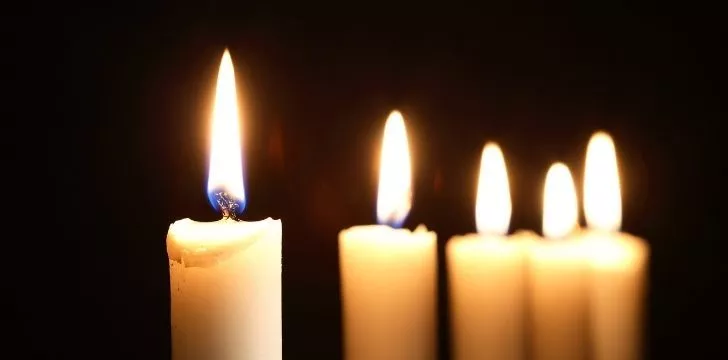5 простых высоких белых свечей, зажженных в темноте