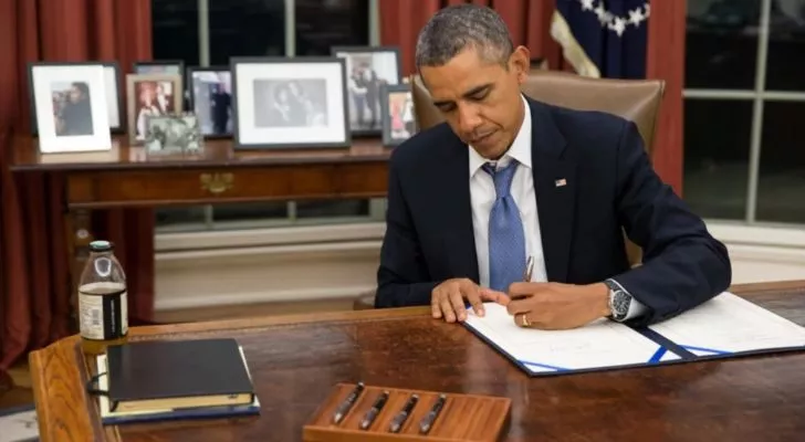Барак Обама подписывает документ в Овальном кабинете