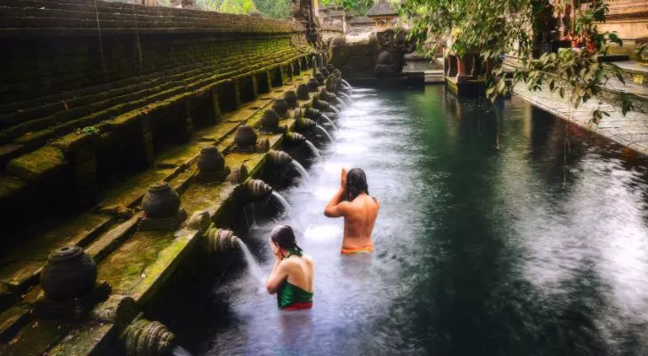 Бассейн в балийском храме с рядом фонтанов, впадающих в него