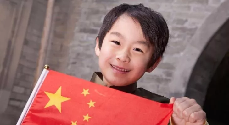 Китайский мальчик держит флаг Китая